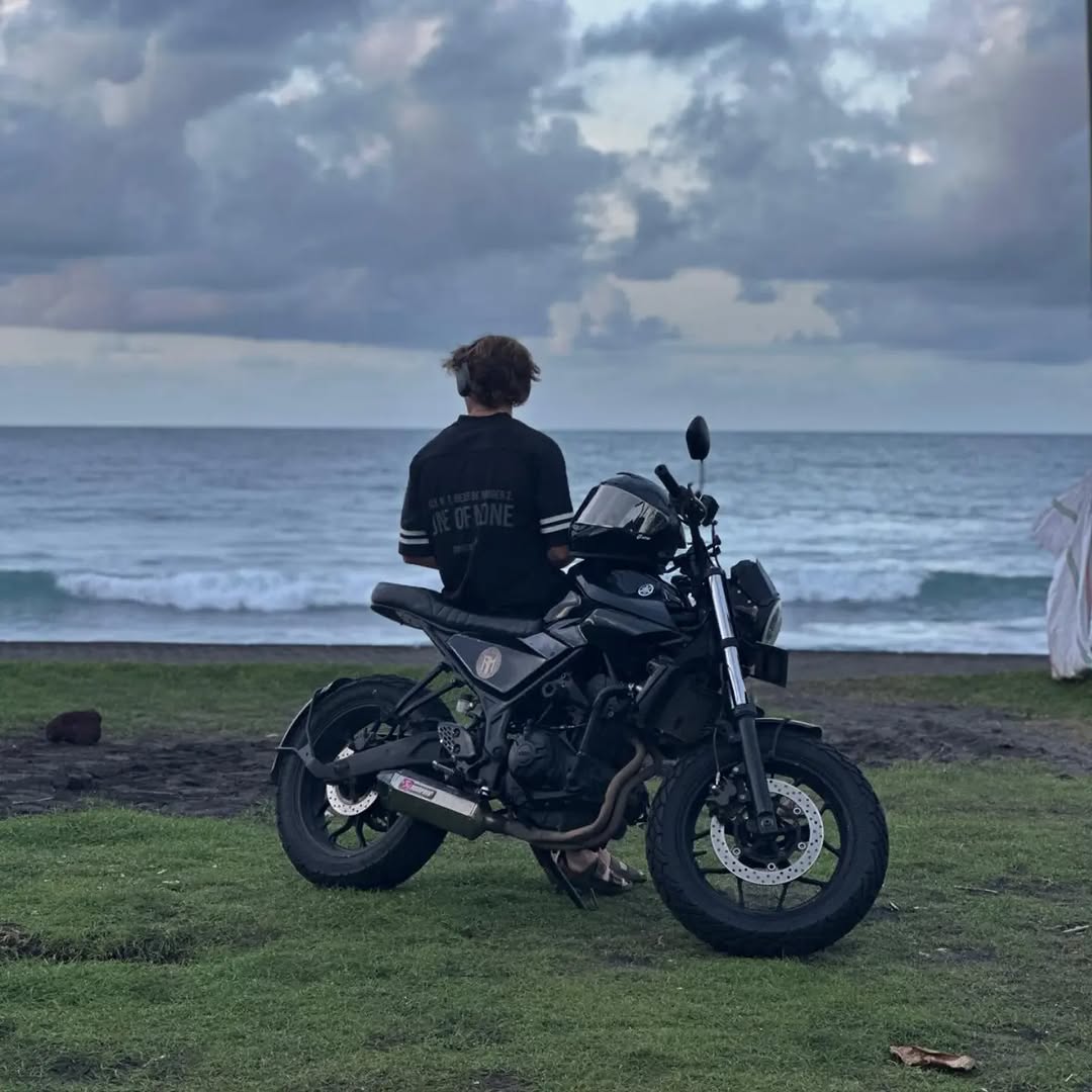 Custom cafe racer motorcycle parked on a tropical Bali road