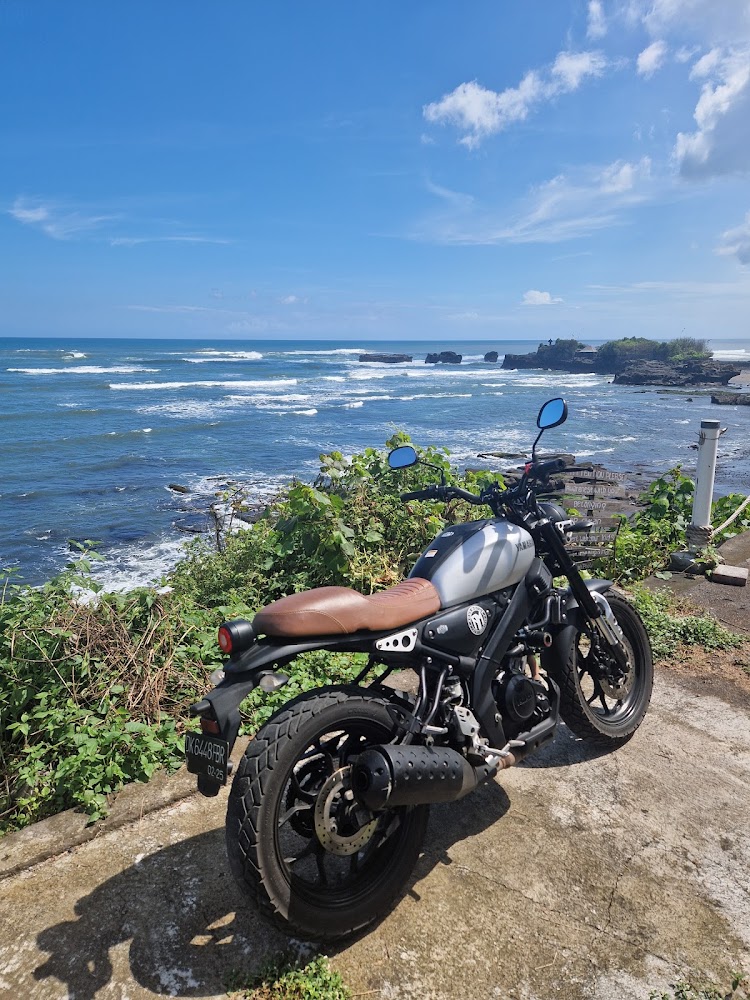 Agus Motor scrambler parked on the Bali coast overlooking the ocean